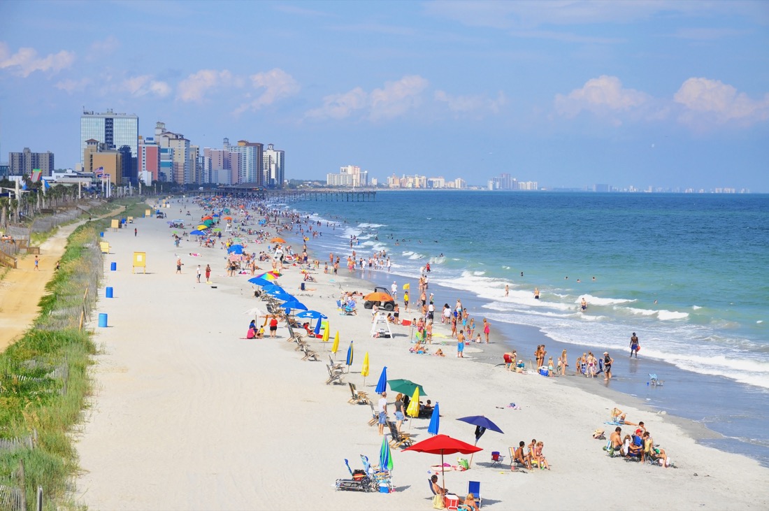 Sandy Myrtle Beach with blue ocean and people sunbathing